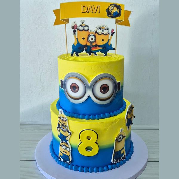 Two-tier birthday cake with Minion characters and the number 8 on a white background