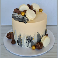 Decorative cake with macarons and chocolate on a white plate against a light blue background