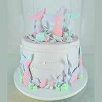 Cake with mermaid tail decorations on a white background