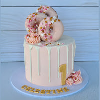 Pink birthday cake with donuts on a white background