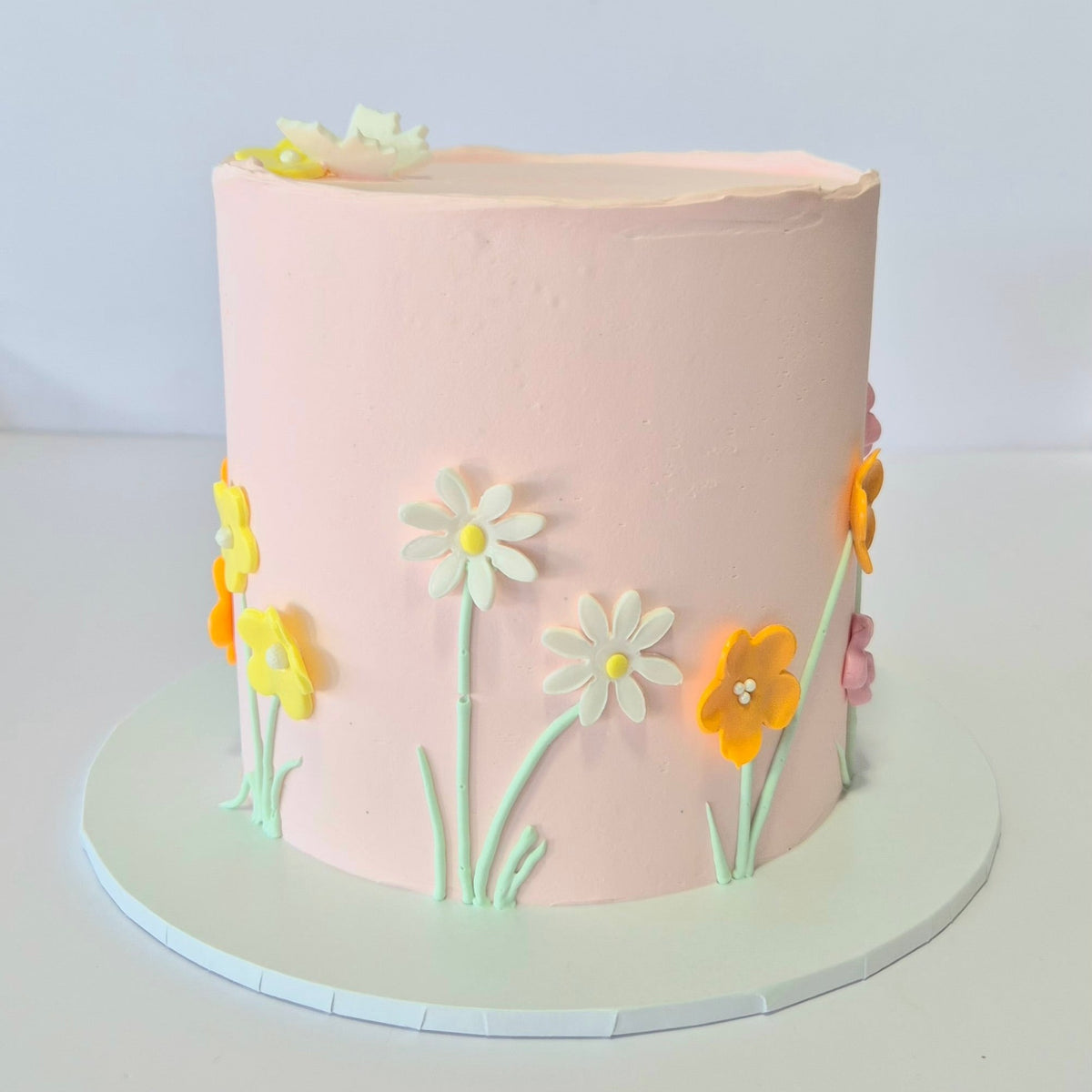 Pink cake with floral decorations on a white background