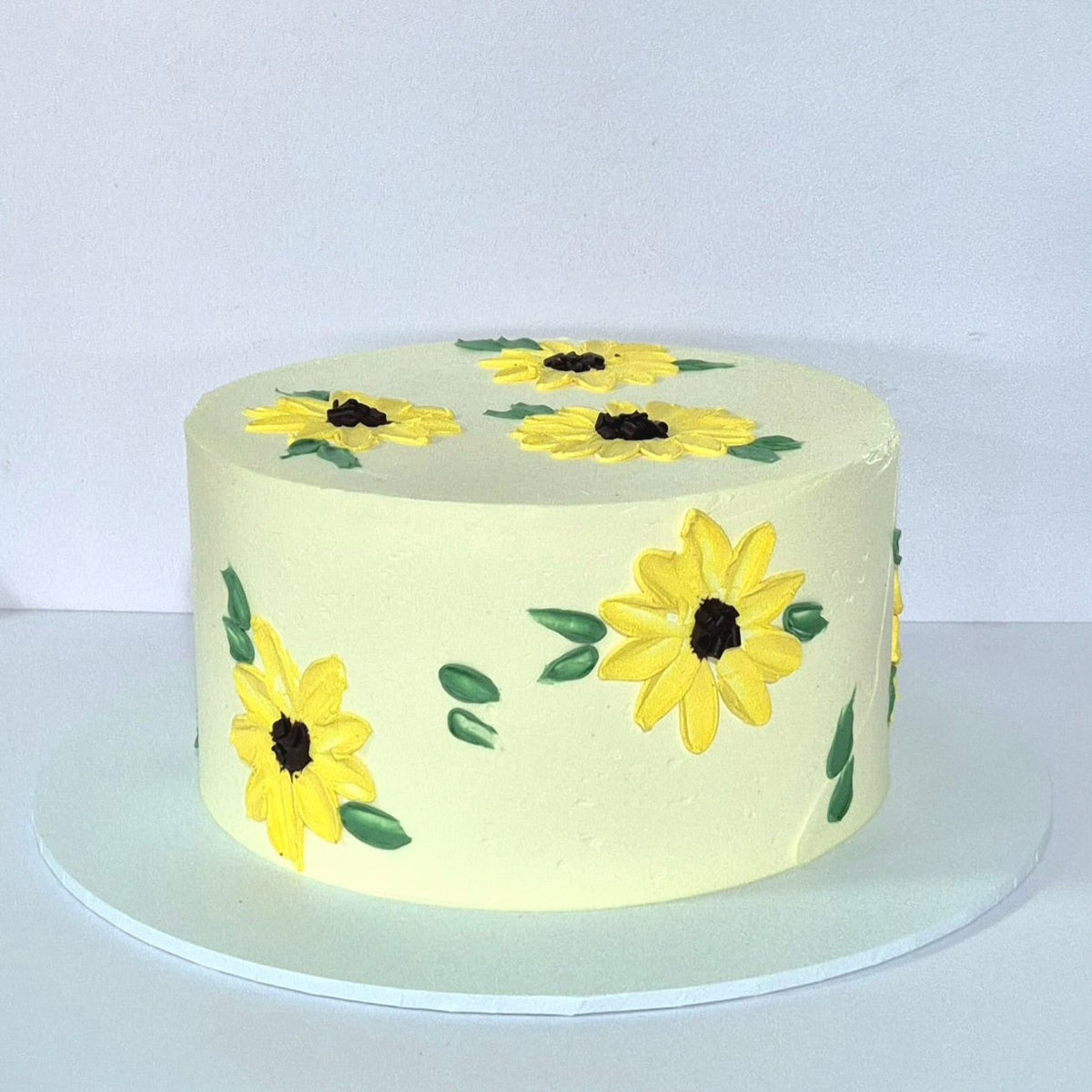 Round cake with yellow flower designs on a white background
