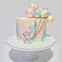 Cake with elephant design and pastel balloons on a white stand